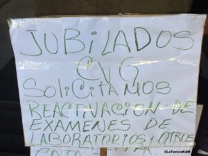 Pancarta con el texto "Jubilados CVG solicitamos reactivación de exámenes de laboratorio"